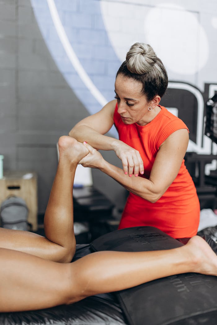 A physical therapist assists a patient with leg rehabilitation at a clinic.